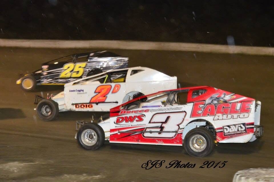 Adam Hilton celebrating on top of his car with the checkered flag